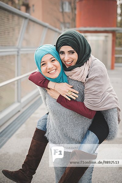 Young woman giving piggyback to friend