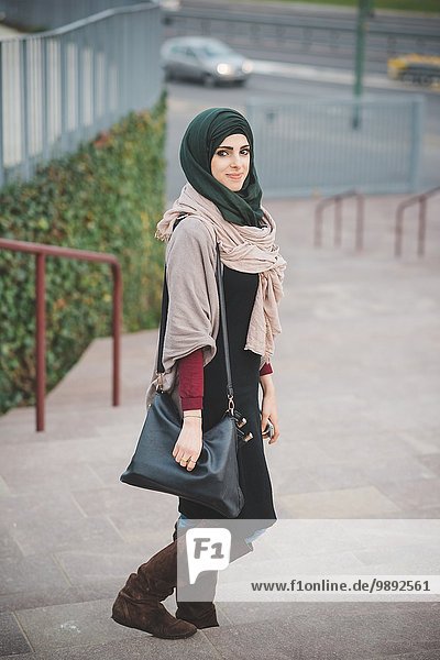 Portrait of young woman wearing hijab on stairway