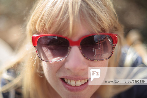 Nahaufnahme eines Frauenportraits mit Sonnenbrille im Außenbereich