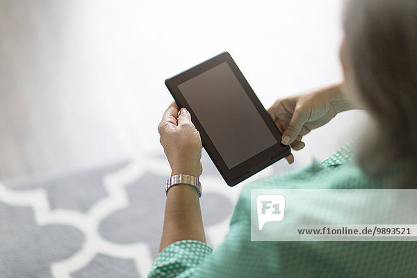 Reife Frau mit digitalem Tablett  Rückansicht
