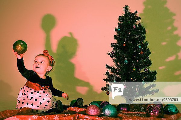 Kleines Mädchen mit einer Weihnachtskugel