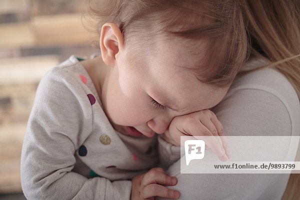 Kleinkind Mädchen weint auf Mutter's Schulter