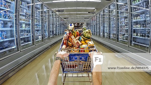 Frau schieben Einkaufswagen Gang Gefriertruhe Supermarkt