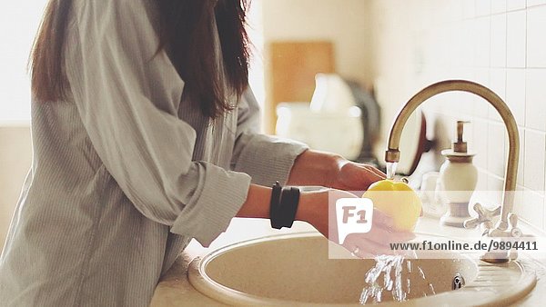 Spülbecken Frau waschen gelb Küche Peperoni