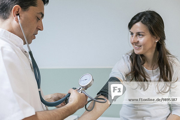 Doctor checking patient's blood pressure