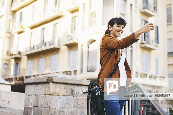 Spanien  Barcelona  lächelnde Geschäftsfrau nimmt Selfie mit Smartphone