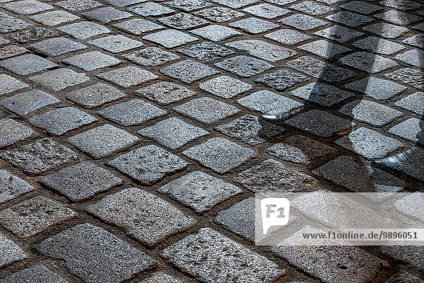 Cobblestone pavement with shadow at night