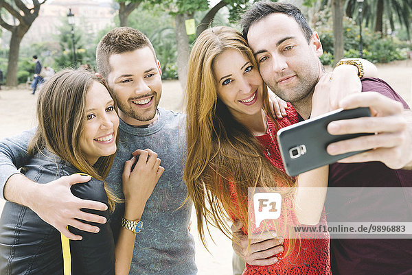 Spanien  vier Freunde  die einen Selfie mit einem Smartphone nehmen