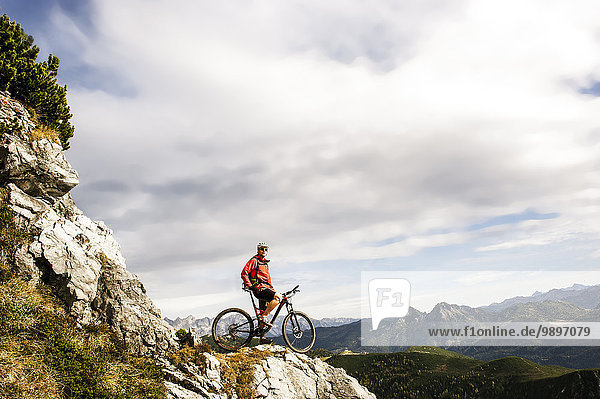 Österreich  Altenmarkt-Zauchensee  junger Mountainbiker mit Blick auf die Niederen Tauern