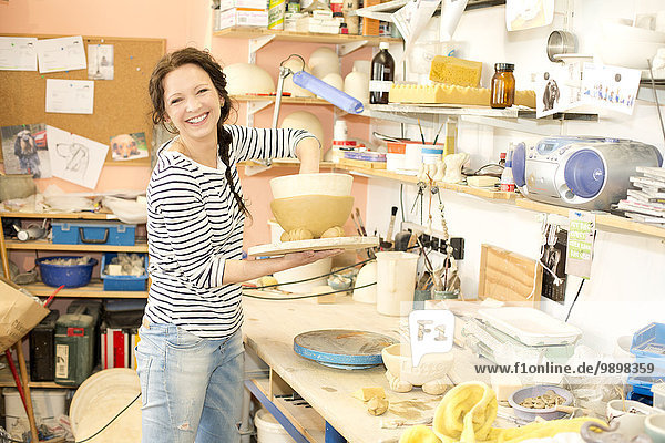 Portrait of smiling potter in studio