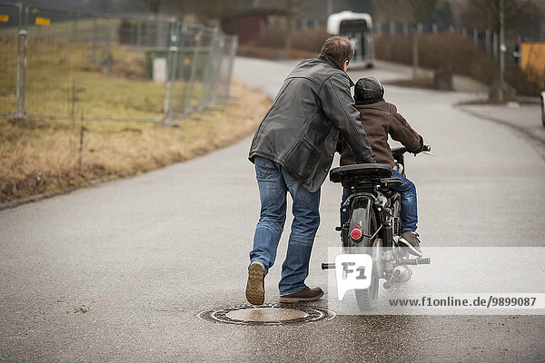 Vater und Sohn fahren mit Oldtimer-Moped