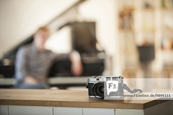 Old camera on table with man in background