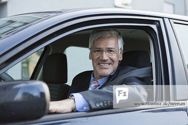 Porträt eines lächelnden Geschäftsmannes im Auto