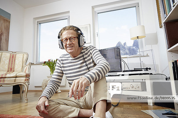 Senior man wearing headphones  listening to music