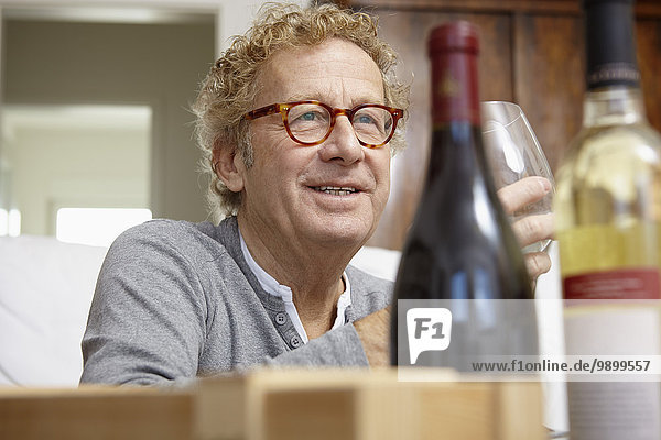 Senior Mann beim Testen von Rot- und Weißwein
