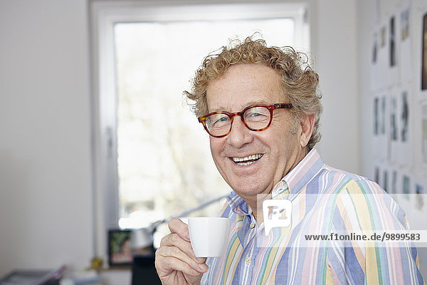 Senior man drinking espresso at home