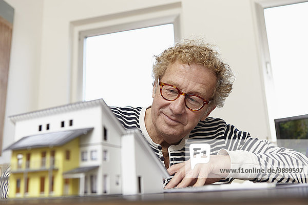 Senior Mann bei der Planung eines Wohnhauses