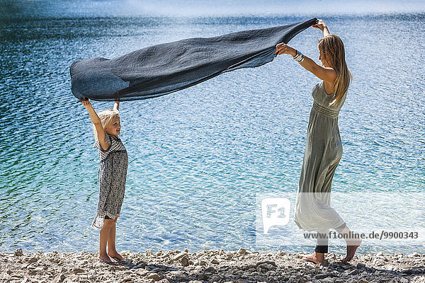 Österreich  Tirol  Plansee  Mutter und Tochter mit Tuch am Seeufer