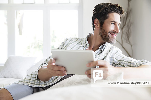 Mature man at home  using digital tablet