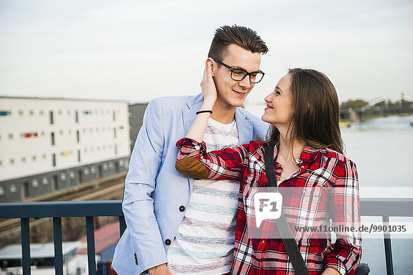 Deutschland,  Mannheim,  lächelndes junges Paar auf der Brücke