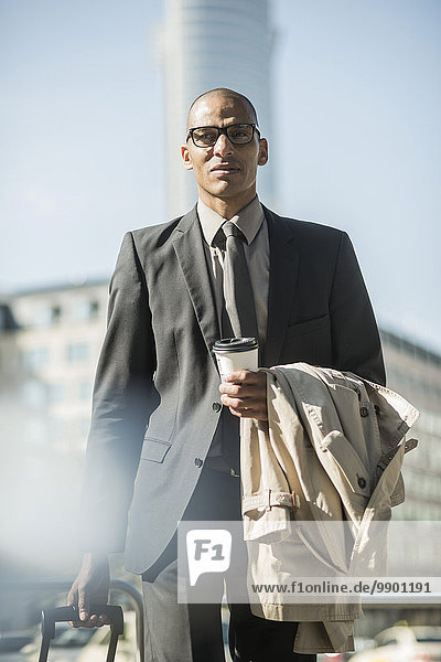 Businessman with suitcase and coffee to go
