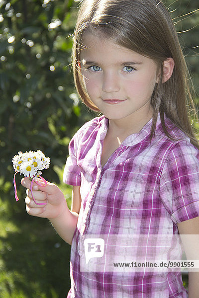 Portrait eines kleinen Mädchens mit Gänseblümchen