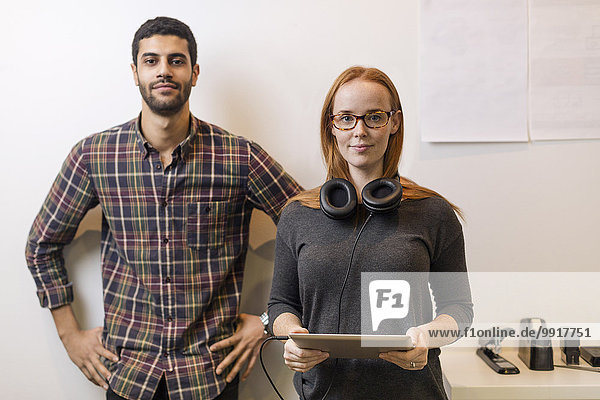 Portrait of confident business colleagues standing by in creative office