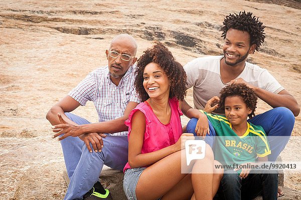 Großvater und Familie sitzen am Felsen Ipanema Beach Rio De Janeiro Brasilien