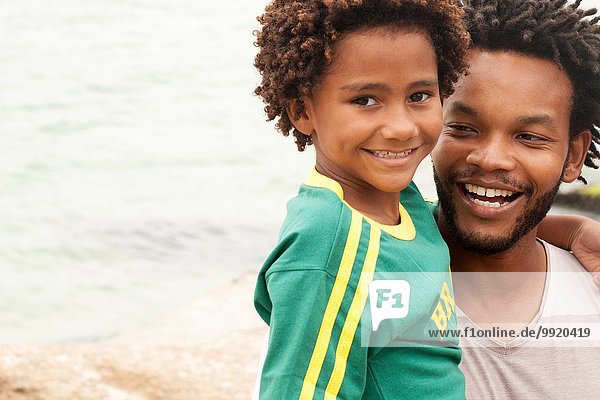 Porträt eines erwachsenen Mannes mit Sohn am Strand von Ipanema Rio De Janeiro Brasilien