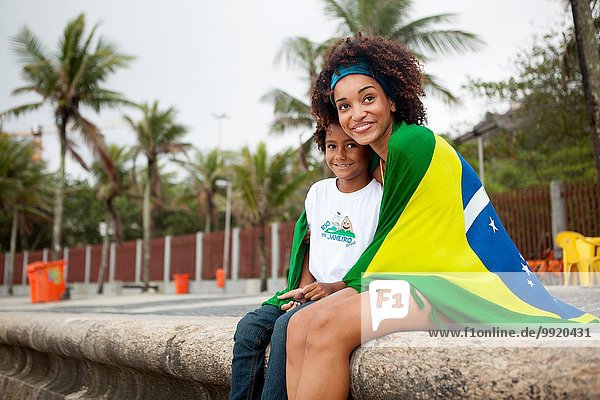 Junge Mutter und Sohn mit brasilianischer Flagge am Strand von Ipanema  Rio De Janeiro  Brasilien