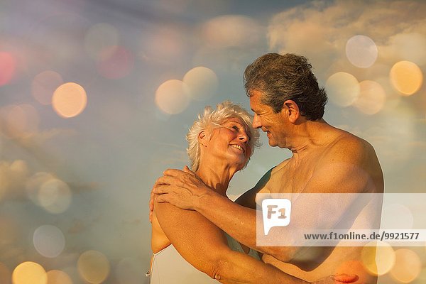 Seniorenpaar beim Umarmen im Urlaub