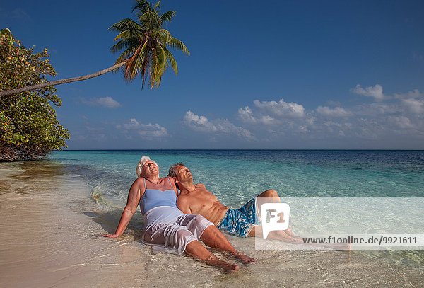 Seniorenpaar entspannt am Strand  Malediven