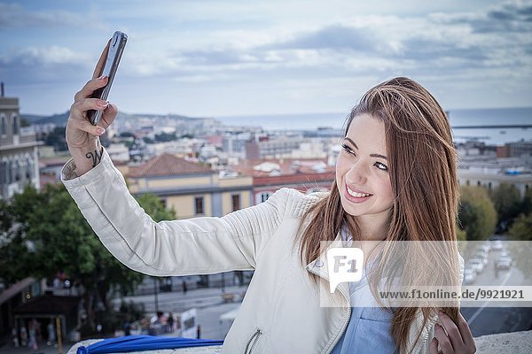 Junge Frau auf dem Dach nimmt Smartphone Selfie  Cagliari  Sardinien  Italien