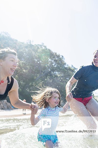 Zwei Frauen und ein Mädchen laufen ins Meer  Hot Water Beach  Bay of Islands  Neuseeland
