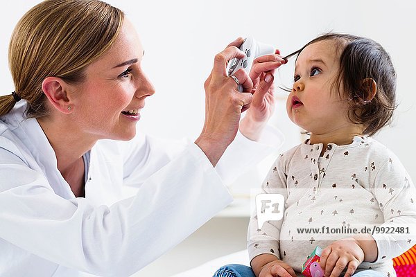 Kinderarzt überprüft die Augen des kleinen Jungen