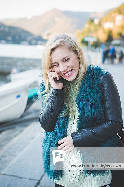 Junge Frau beim Chatten auf dem Smartphone am Comer See  Comer See  Italien
