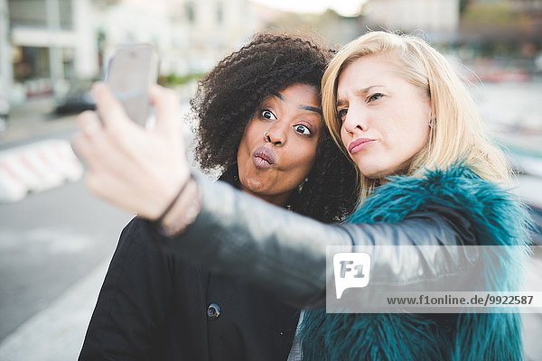 Zwei junge Frauen ziehen Gesichter für Smartphone Selfie  Comer See  Comer See  Italien