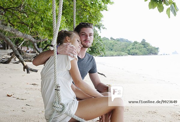 Young couple sitting on beach swing  Kradan  Thailand