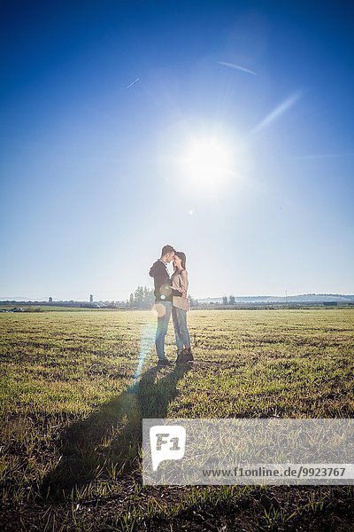 Young couple hugging in field