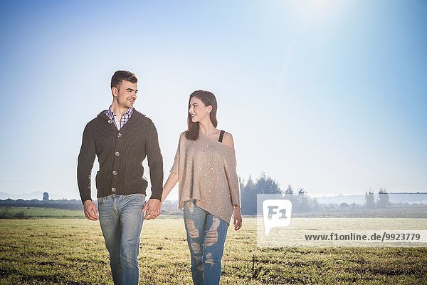 Young couple walking in field