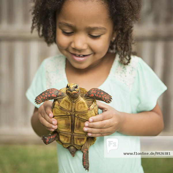 A child holding a tortoise.