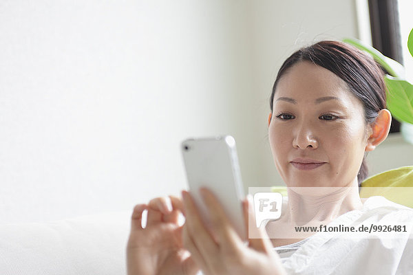 Woman using a Smartphone on the sofa