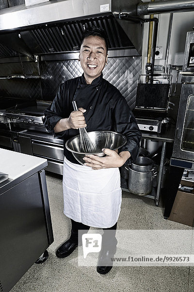A cook in a commercial restaurant kitchen.