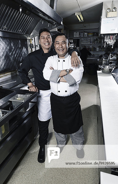 Two cooks in a commercial restaurant kitchen.