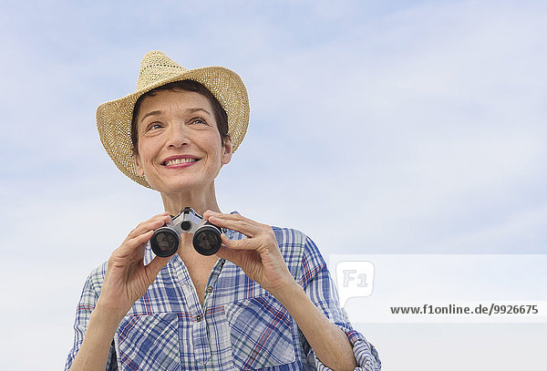 Smiling senior woman with binoculars