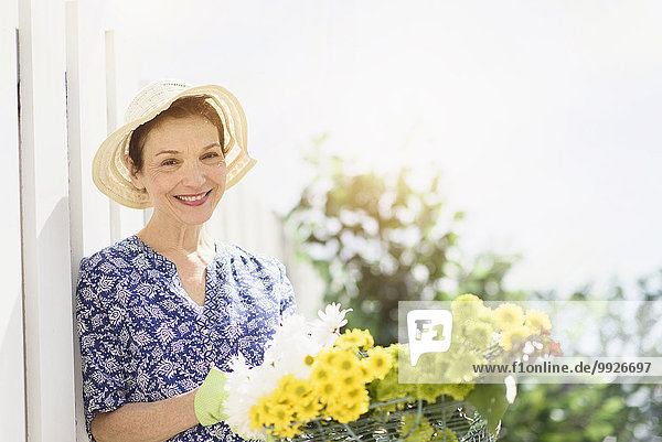 Portrait of smiling senior woman with flowers