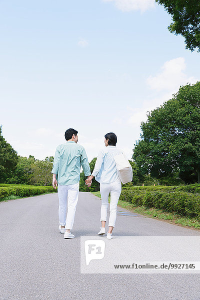 Japanese couple walking in a city park
