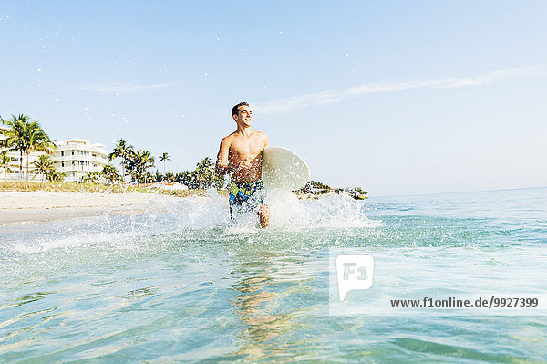 Young surfer running