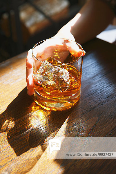 Young Japanese woman with glass of whiskey in a fashionable bar