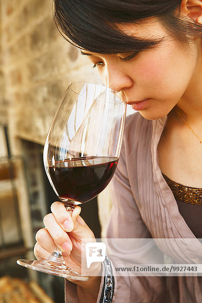 Young Japanese woman tasting wine in a fashionable bar